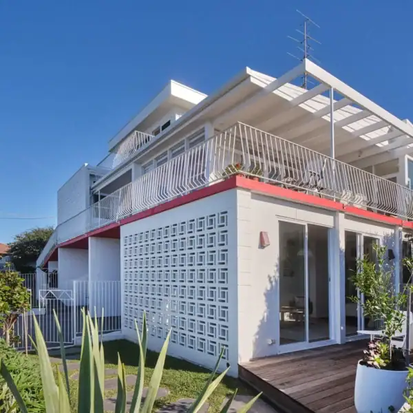 architectural coastal renovation with red steel balcony and ocean views