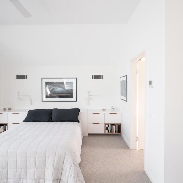 Modern master bedroom with custom white cabinetry and minimalist interior design in an Austinmer coastal home by Simpson and Co Projects.