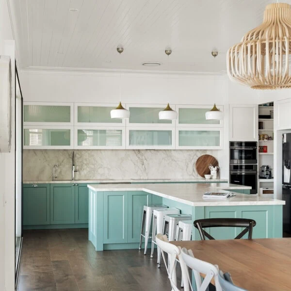 Coastal kitchen with mint cabinetry, marble splashback, pendant lighting and custom joinery at Wombarra No. 3.