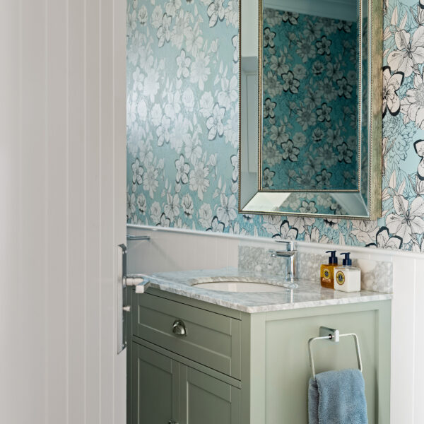 Custom bathroom vanity with green cabinetry, coastal floral wallpaper and marble benchtop at Wombarra No. 3.