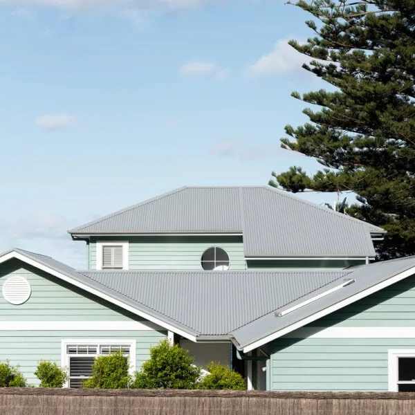 Coastal home facade showing the upper gable, mint-green weatherboards and white trims at Wombarra No. 3.