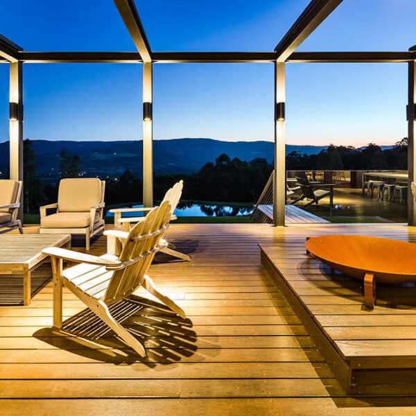 Architect-designed outdoor lounge at Ooralba Estate featuring timber decking, built-in seating, and open pergola structure overlooking Kangaroo Valley, constructed by Simpson & Co.