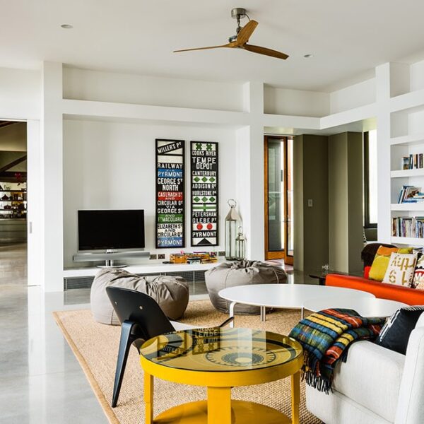 Bright open-plan living area at Ooralba Estate with white architectural columns, built-in shelving, modern dining furniture, and a contemporary lounge setting in a custom Kangaroo Valley residence.