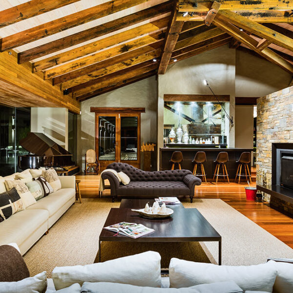 Architect-designed great room at Ooralba Estate featuring exposed timber trusses, large stone fireplace, and curated furnishings, built by Simpson & Co in Kangaroo Valley.