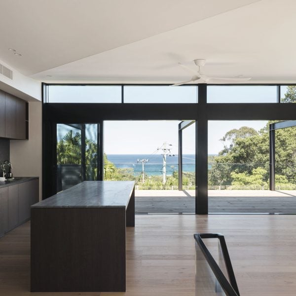 Open-plan living area in Stanwell Park coastal custom home with large glazing framing ocean views.