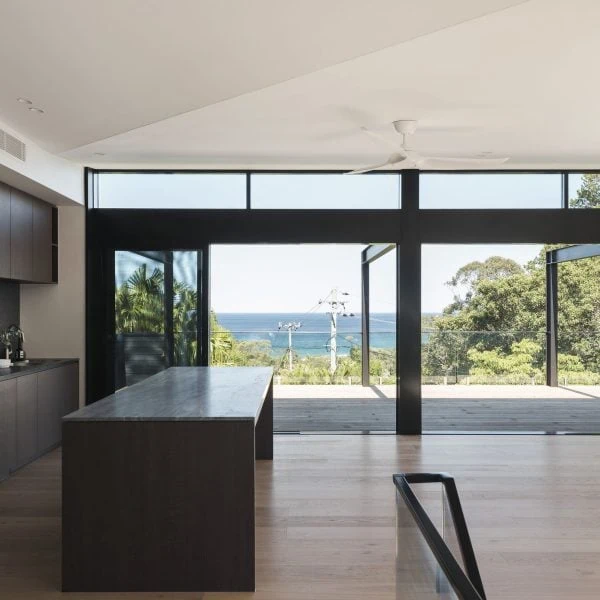 Open-plan living area in Stanwell Park coastal custom home with large glazing framing ocean views.