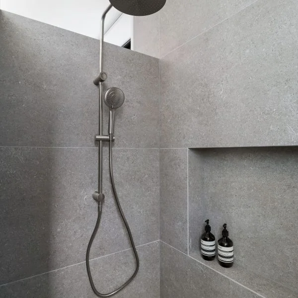 Walk-in shower rainhead detail in Stanwell Park coastal custom home with minimalist architectural finish