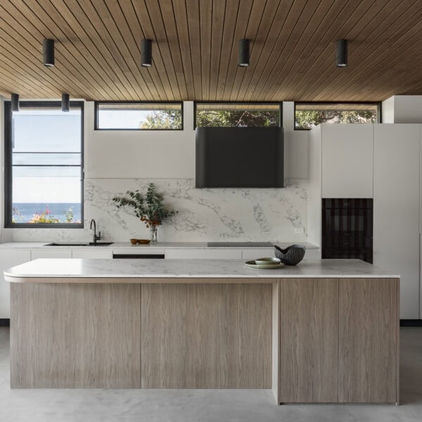 Contemporary kitchen in Stanwell Park No.3 featuring a stone island, timber ceiling and natural light.