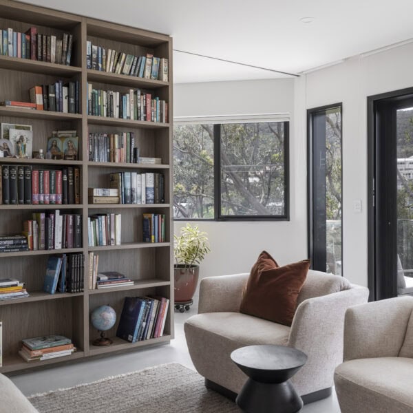 Living room with custom library shelving, lounge seating and natural light in Stanwell Park No.3.