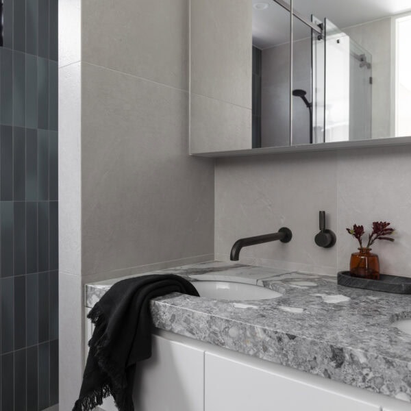 Stone bathroom vanity with black tapware, custom joinery and mirror in Stanwell Park No.3.