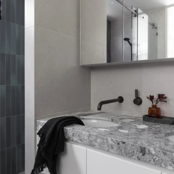 Stone bathroom vanity with black tapware, custom joinery and mirror in Stanwell Park No.3.