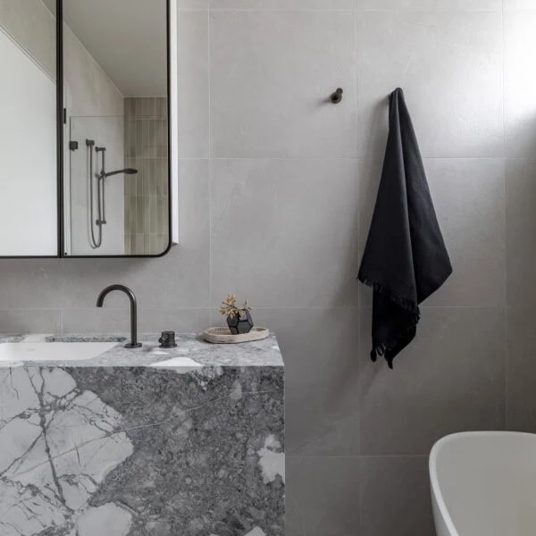 Stone bathroom vanity with custom joinery and black tapware in Stanwell Park No.3.