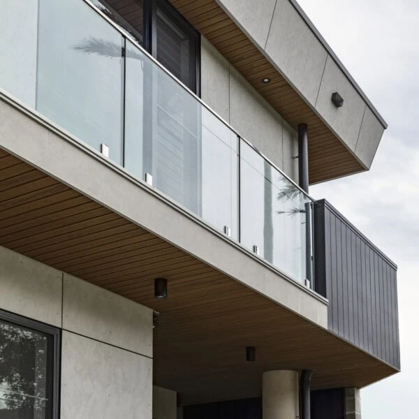 Upper balcony of Stanwell Park No.3 featuring glass balustrades, timber soffit and contemporary coastal detailing.