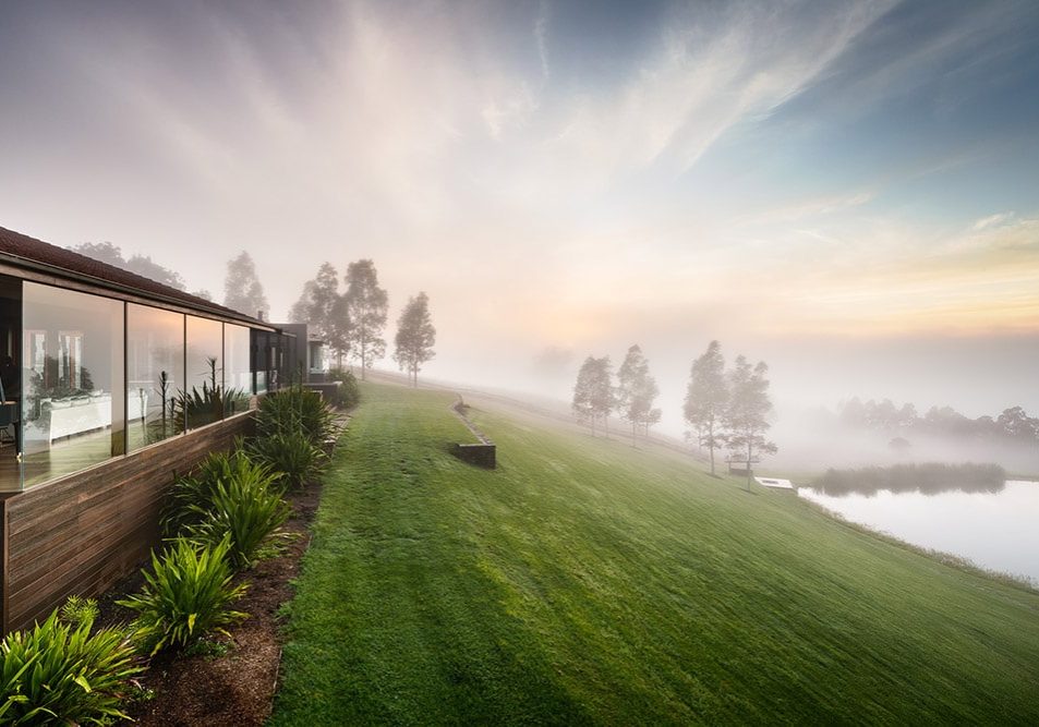 Architect-designed exterior façade at Ooralba Estate with timber and stone detailing, built by Simpson & Co and overlooking misty morning views across Kangaroo Valley.